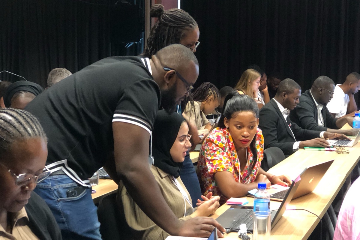 Instructor working with participants at laptops